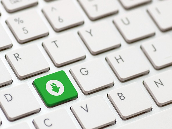 white computer keyboard with a green button with an arrow pointing down